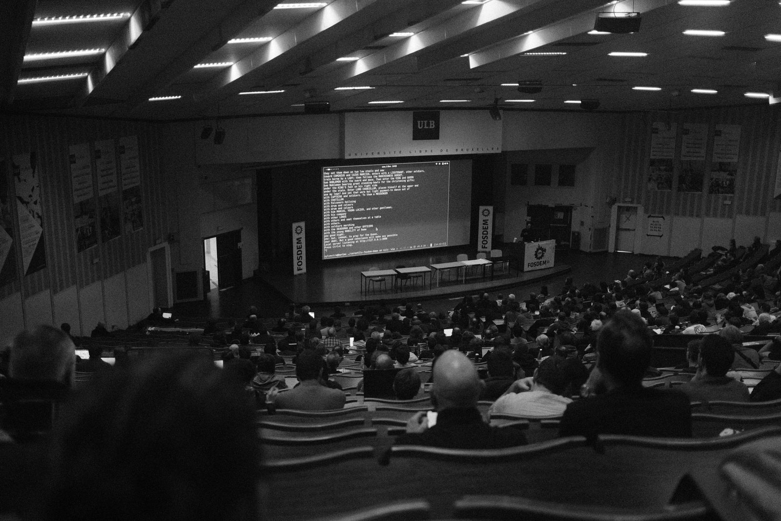 Photographie en noir et blanc d'une conférence technologique à l'auditorium de l'ULB, à Bruxelles.